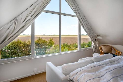 een slaapkamer met een bed en een groot raam bij Farmhouse near Malmö in Trelleborg