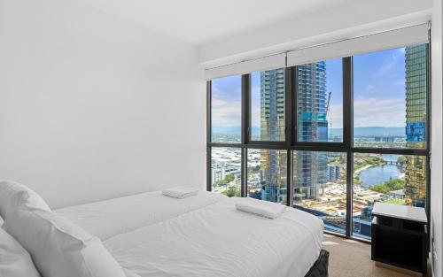 a bedroom with a white bed and a large window at Convenient Located 2 Bedroom Apartment Next to Casino in Gold Coast