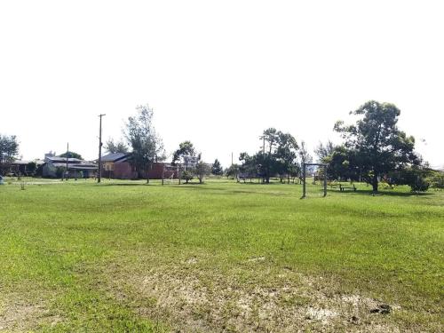 duże pole zielonej trawy z drzewami w obiekcie Casas no Balneário Pérola / Arroio do Sal w mieście Arroio do Sal
