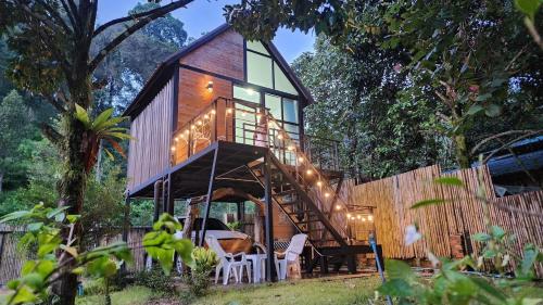 a tree house with a deck and a staircase at p.p. hill & house in Ban Tha Phae