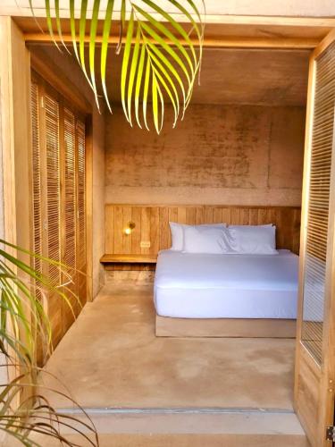 a bedroom with a white bed and a chandelier at Casa Naya in Puerto Escondido
