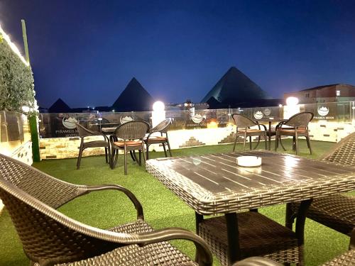 um pátio com uma mesa e cadeiras à noite em Pyramids moon view em Cairo