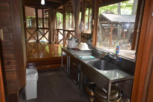 una cucina con lavandino e finestra in una casa di Tabino Camping Base Akiu Tree House - Vacation STAY 23969v a Yumoto