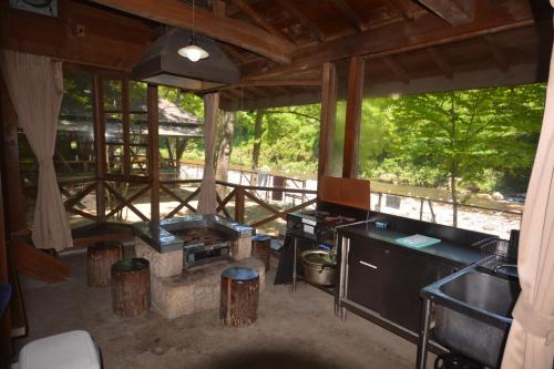 Tabino Camping Base Akiu Tree House - Vacation STAY 23970v في Yumoto: غرفة مع مطبخ مع حوض ومكتب