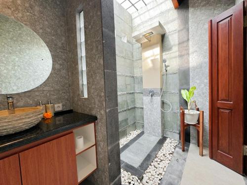 La salle de bains est pourvue d'un lavabo et d'une douche. dans l'établissement Villa magica 2, à Ubud