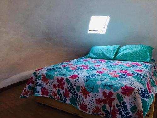 Domo Sol Del Valle في Horcon: غرفة نوم مع سرير مع لحاف ملون
