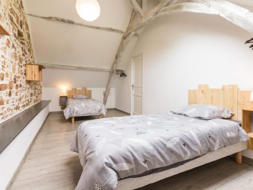 1 dormitorio con 1 cama grande y pared de ladrillo en Gîte Vallons-de-L'Erdre, 4 pièces, 7 personnes - FR-1-306-873, en Vallons-de-l'Erdre