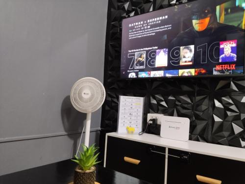 a desk with a fan and a flat screen tv at Nice 1BR Condo Unit by Lee Portum in Marilao