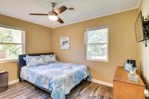 a bedroom with a bed and two windows at Lovely Emerald Isle Home, Walk to Beach! in Emerald Isle