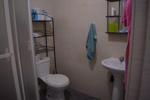 La salle de bains est pourvue de toilettes et d'un lavabo. dans l'établissement Casa privada en Tonsupa con piscina, à Tonsupa
