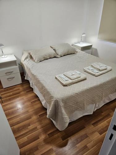 a bedroom with a bed with two towels on it at Departamento centrico in Ushuaia