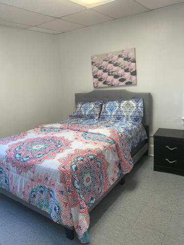 a bedroom with a bed with a colorful comforter at Muna’s Place in Newark