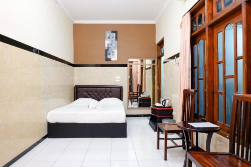 a bedroom with a bed and a table and chairs at Dya Hotel Boyolali in Boyolali