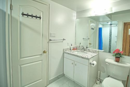 a white bathroom with a toilet and a sink at Private Bathroom and a Free Parking in Vaughan