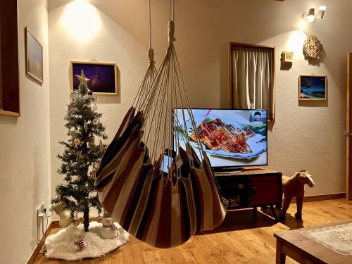 ein Wohnzimmer mit einem Weihnachtsbaum und einer Schaukel in der Unterkunft Villa Yui in Ishigaki-jima