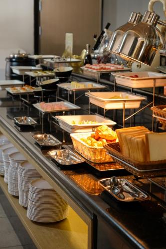 a buffet line with many plates and food on at SHANGHAI-DECO Hotel-Free shuttle bus to Pudong Airport and Disneyland in Shanghai