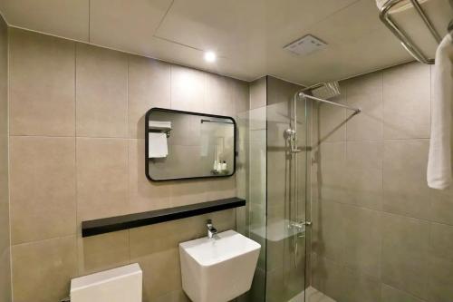 a bathroom with a sink and a mirror and a shower at Hotel141 in Daejeon