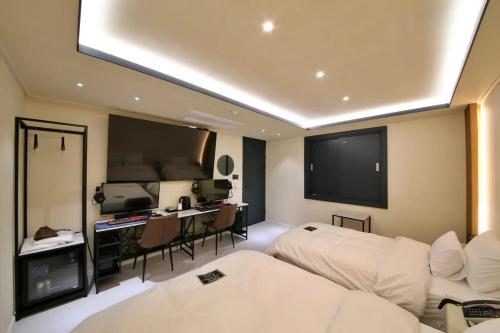 a room with two beds and a flat screen tv at Hotel141 in Daejeon