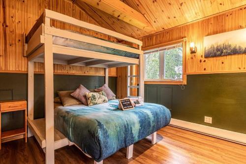 a bedroom with a bunk bed in a cabin at Refuge Rustic bordé par rivière et la nature in Sainte-Germaine-du-Lac-Etchemin