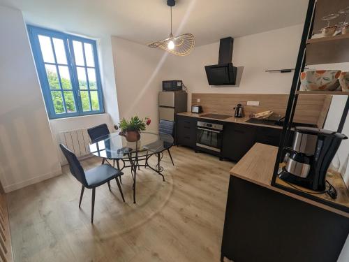 une cuisine avec une table et des chaises dans une pièce dans l'établissement Gîte dans ancien presbytère avec parc à Langres - FR-1-611-74, à Langres