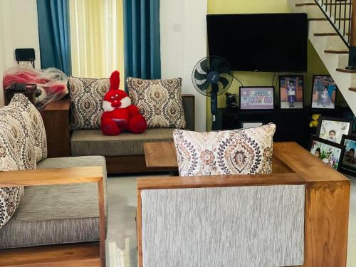 a living room with a red teddy bear sitting on a couch at Guruge Home Stay in Ambalantota