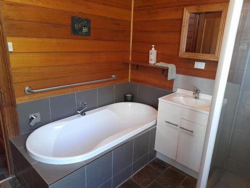 een kleine badkamer met een bad en een wastafel bij Three Bedroom Escape with Room to Roam in Rocky Cape