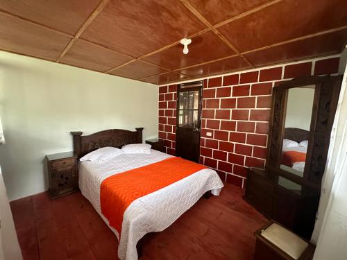 um quarto com uma cama e uma parede de tijolos em sol solegüa em Cajamarca