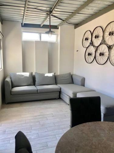 a living room with a couch and clocks on the wall at Terraza parque revolución in Ensenada