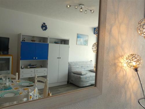 un miroir reflétant un salon avec une table et une chaise dans l'établissement Studio face à la mer avec balcon et parking - 4 pers, Saint-Jean-de-Monts - FR-1-323-428, à Saint-Jean-de-Monts