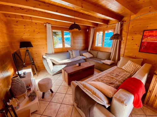 - un salon dans une cabane en rondins avec un canapé et une table dans l'établissement Chalet traditionnel avec garage double et terrasse - FR-1-459-227, à La Clusaz