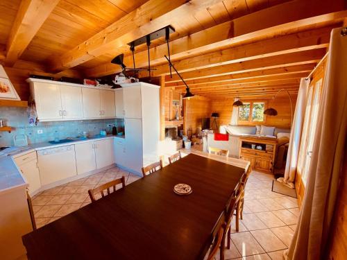 une cuisine avec une table en bois et une salle à manger dans l'établissement Chalet traditionnel avec garage double et terrasse - FR-1-459-227, à La Clusaz