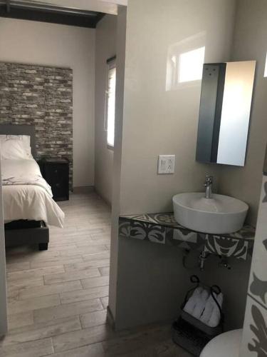 a bathroom with a bed and a sink in a room at Terraza parque revolución in Ensenada