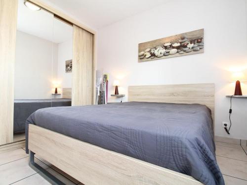 a bedroom with a bed with a blue bedspread at Appartement T2 avec clim, parking et wifi - Balaruc-les-Bains - FR-1-553-241 in Balaruc-les-Bains