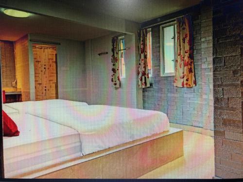 a bedroom with a large white bed and windows at City hotel in Sibu