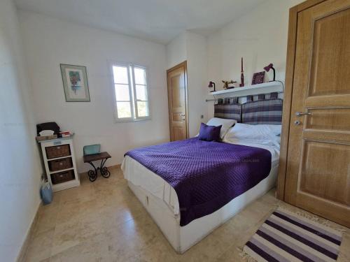 une chambre avec un lit avec une couette violette dans l'établissement Appartement T3 avec piscine et terrasse, à 200m du centre de La Croix-Valmer - FR-1-100-324, à La Croix-Valmer