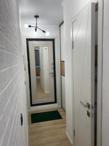 bagno con specchio e corridoio con porta di 1-комнатная квартира a Ekibastuz