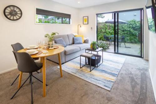 a living room with a table and a couch at Central City-Urban Oasis 1 bed 1 bath w/sofa bed in Christchurch