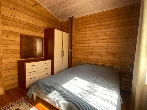 een slaapkamer met een bed, een dressoir en een spiegel bij Милая квартира премиум класса in Alma-Ata