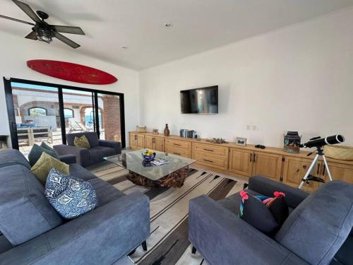 a living room with two couches and a table at Villa Tres Vistas. in El Pescadero