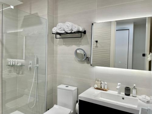 a bathroom with a shower and a toilet and a sink at Gorgeous 2 bedroom, 17th floor, with breathtaking view, Fourteen at Mullet Bay in Cupecoy