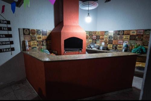 - une cuisine avec un four à pizza au milieu dans l'établissement Rancho Romanichen, à Itaboraí