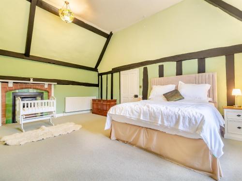 a bedroom with a large bed and a fireplace at Sycamore Farmhouse in Ipswich