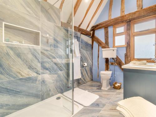 a bathroom with a glass shower and a toilet at Sycamore Farmhouse in Ipswich