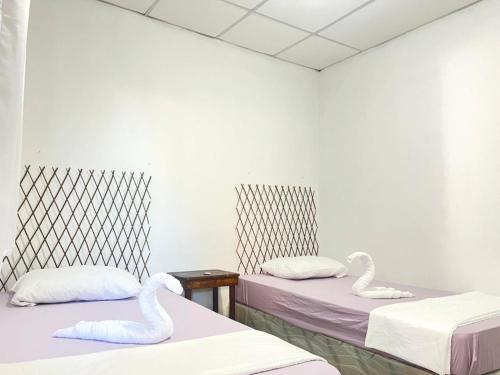 two beds in a room with swans on them at Hostal Villa Marta in Santa Ana
