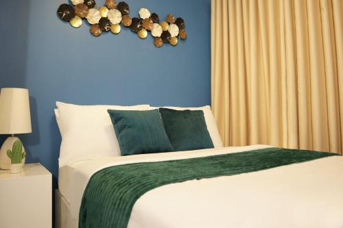 マニラにあるHomefort at S Residencesの青い壁のベッドルーム1室(大型ベッド1台付)