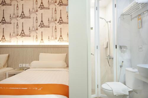 un piccolo bagno con letto e doccia di Front One Hotel Sragen a Sragen