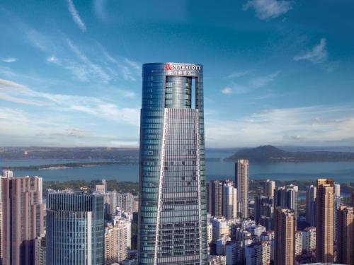 a tall building with a sign on it in a city at Wuhan Marriott Hotel Wuchang in Wuhan