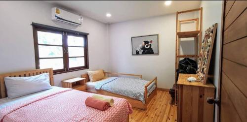 a bedroom with a bed and a bunk bed at Rock Garden Beach D19 Pool Villa in Rayong
