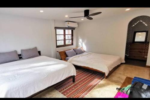 a bedroom with two beds and a window at Rock Garden Beach D19 Pool Villa in Rayong