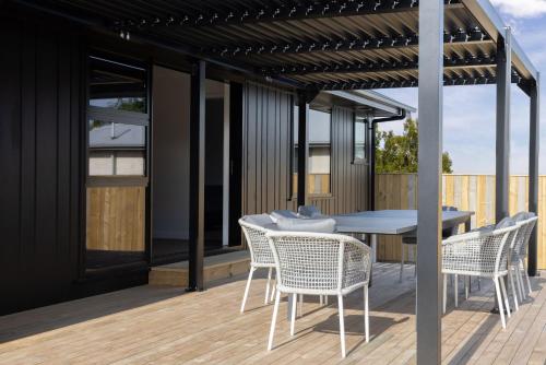 a patio with a table and chairs on a deck at The Corner on Te Mata in Havelock North